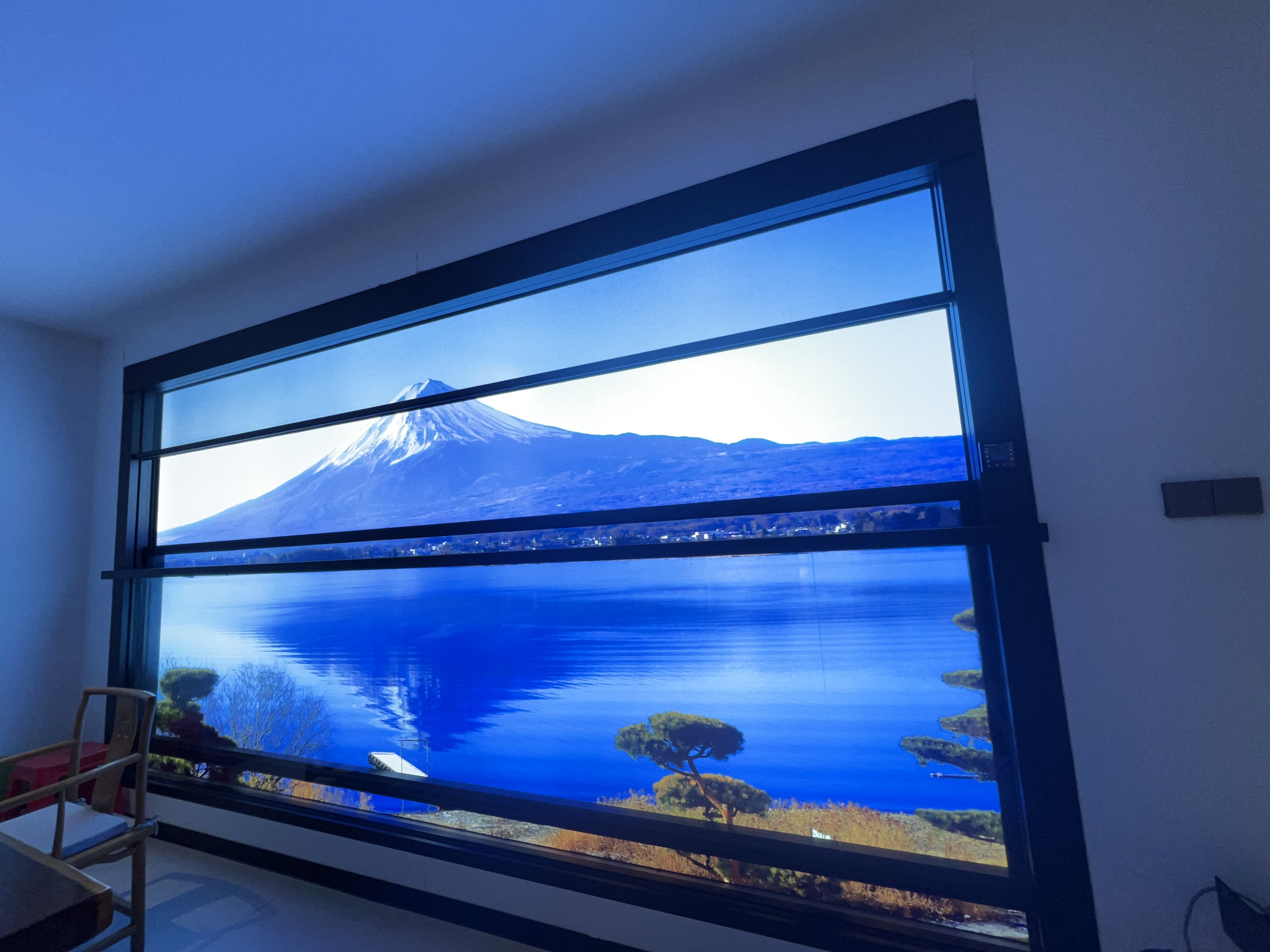 Vertical lifting window in a showroom with a landscape display